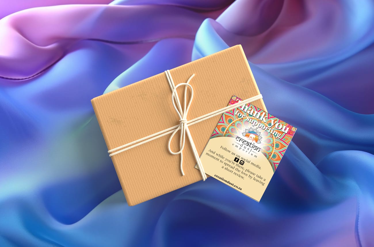 A vibrant, artisanal thank you card for Creation Dust Emporium. The upper half features an intricate, multi-colored mandala pattern with a glowing center highlighting the elephant logo. The lower half is a clean, parchment-colored section with social media icons and a call-to-action for customer reviews, reflecting a blend of traditional Indian art and modern marketing layout.